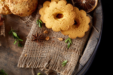 Conceptual composition with assortment of cookies on burlap napkin on a wooden barrel, selective focus, close-up