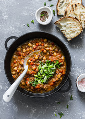 Vegetarian buffalo chickpea chili with mushrooms in a pan on a gray background, top view. Healthy vegetarian food concept