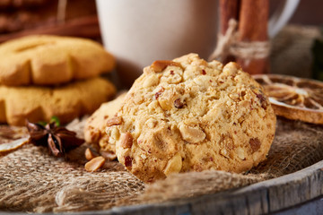Conceptual composition with assortment of cookies on burlap napkin on a wooden barrel, selective focus, close-up