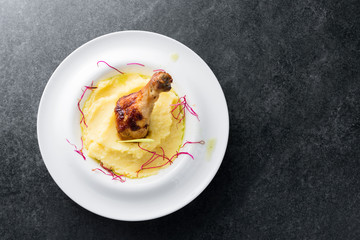 Mashed potatoes with chicken leg appetizing on a white plate