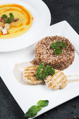 Complex dinner. Buckwheat porridge with dietary meat on a white plate is tenderly served