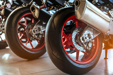 Closeup of new motorbike rear wheel . Big bike parked in showroom of dealership.  Motorcycle...