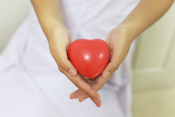 A couple' hands holding a red heart to give with love and romance on Valentine's day concept