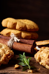 Christmas composition with chocolate biscuits, cinnamon a on wooden background, close-up.