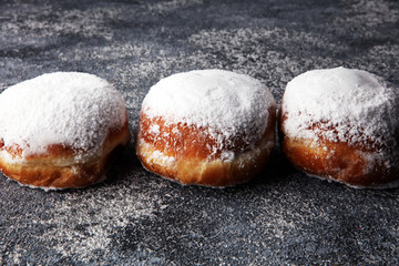 German donuts with jam and icing sugar. Carnival powdered sugar raised donuts