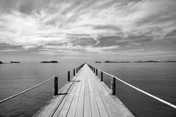 Fototapete Meer / Ozean Schwarz-Weiß-Landschaft der Holzbrücke im blauen Meer am tropischen Strand.