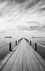 Poster Zwart-wit landschap van houten brug in blauwe zee op tropisch strand. © oatautta