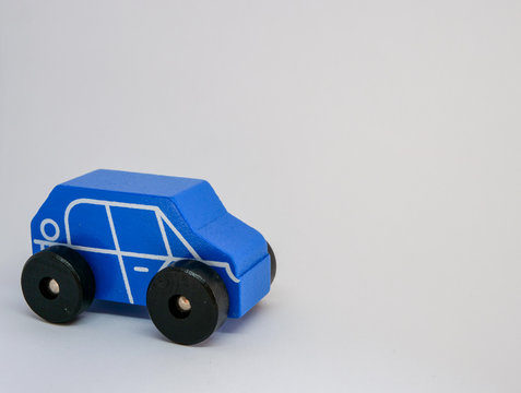 A toy car made of wood, a place for text, close-up, isolated