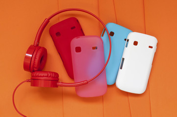 bright headphones and covers for the phone on an orange background