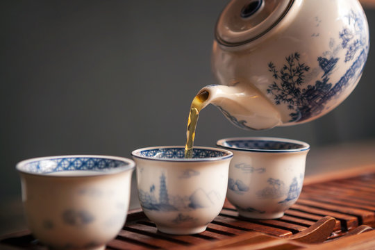 Fototapeta Cropped shot of pouring tea in traditional chinese teaware.