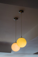 Light shining orange spheres hanging from the ceiling.
