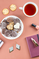 Flat lay home office desk. Feminine workspace with diary, flowers, sweets, fashion accessories. Fashion blogger concept.