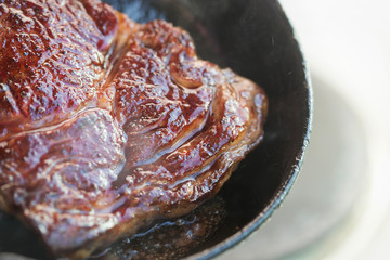 Rib eye steak fried on vegetable oil on iron cast