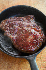 Rib eye steak fried on vegetable oil on iron cast