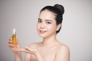 Obraz na płótnie Canvas Beauty concept. Asian pretty woman with perfect skin holding oil bottle