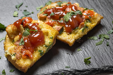 Delicious homemade fried egg in toast for breakfast with frankfurters, onion, cheese and herbs