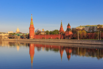 Fototapeta premium Moscow Kremlin towers with reflection in water of Moskva river on a sunny spring morning