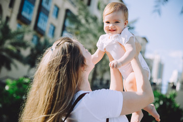 Happy mother holding her adorable little daughter