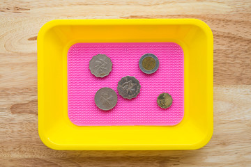 Coins of the Japanese yen in colorful coin tray on wooden table - Small business concept