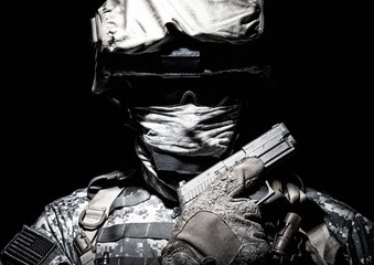 Special operations forces soldier in combat helmet with hidden behind balaclava and dark glasses...