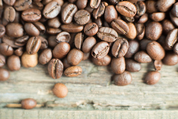 Roasted coffee beans on rustic wooden background. Food ingredients, top view, space for text