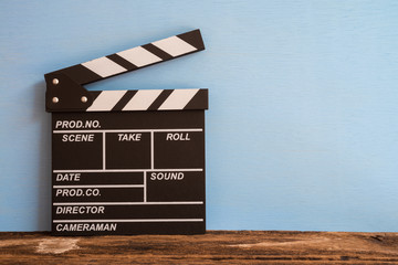 Cinema clapperboard on old wooden with blue wooden wall background - Movie entertainment concept
