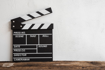 Cinema clapperboard on wooden with white wall concrete background - Movie entertainment concept