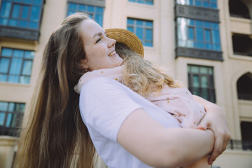 Happy beautiful mother holding her adorable little daughter, contemplating amazing Arabic...