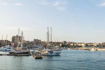 Fototapeta na wymiar Ships, yachts and sailboats docked in Siracusa, Sicily, Italy