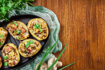 Baked potatoes in jacket stuffed with bacon, mushrooms and chees