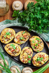 Baked potatoes in jacket stuffed with bacon, mushrooms and chees