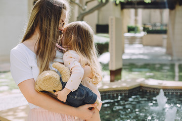 Happy beautiful mother having fun with her adorable little daughter on a sunny day