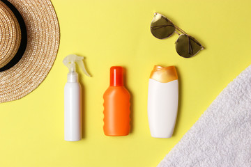sunscreen, towel, hat, glasses on a colored background. Cosmetics for prevention of sunburn. top view, flatlay 
