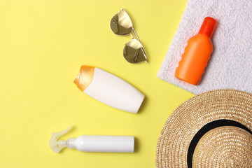 sunscreen, towel, hat, glasses on a colored background. Cosmetics for prevention of sunburn. top view, flatlay 