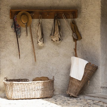Front view of a retro style outdoor wardrobe with walking sticks, backpacks, baskets and travel equipment.