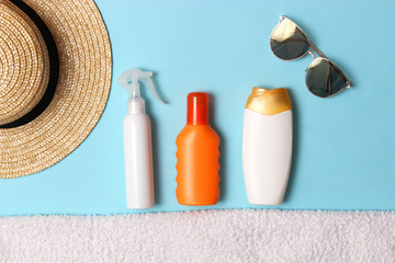 sunscreen, towel, hat, glasses on a colored background. Cosmetics for prevention of sunburn. top view, flatlay 