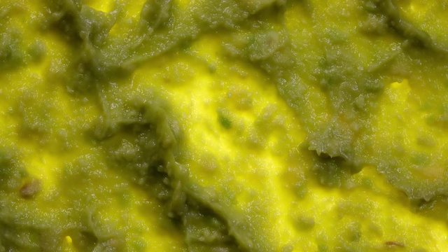 Avocado smash rotating in 4K. Closeup flat-lay view. Traditional tasty sauce guacamole.
