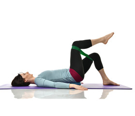 Woman exercising doing postnatal workout. Female fitness instructor working out with a rubber...