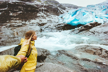 Couple follow hands holding in glacier mountains Traveling together healthy lifestyle concept active adventure vacations into the wild