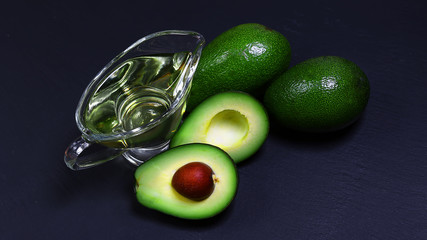 Green avocados and avocado oil on a shale board, the concept of healthy eating, copy space, top view set