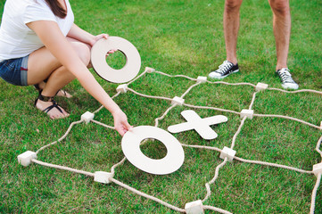 Big Tic Tac Toe game. Guy and girl playing outdoors.