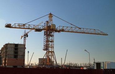 Tower cranes are working on the construction of a new house. Lifting crane.