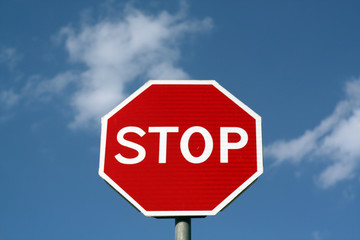 Stop sign against cloudy sky.