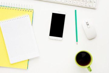 white desk, computer, Cup of coffee, white smart phone lies on the desk,  office supplies,  white background with copy space, for advertisement, top view