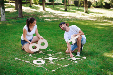 Big Tic Tac Toe game. Guy and girl playing outdoors.