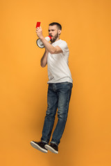 Football supporter with red card on orange background