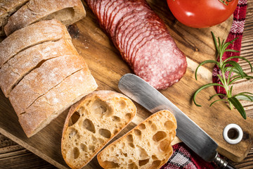 Italian ciabatta bread cut in slices with salami.