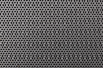 close up on a mettalic texture with small holes