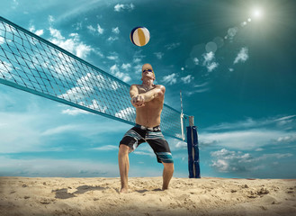 Beach volleyball player in action at sunny day under blue sky.
