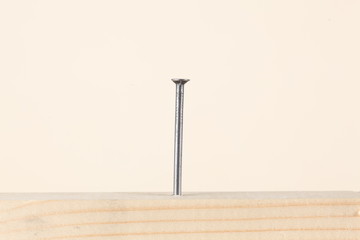 a nail fixed in a wooden board